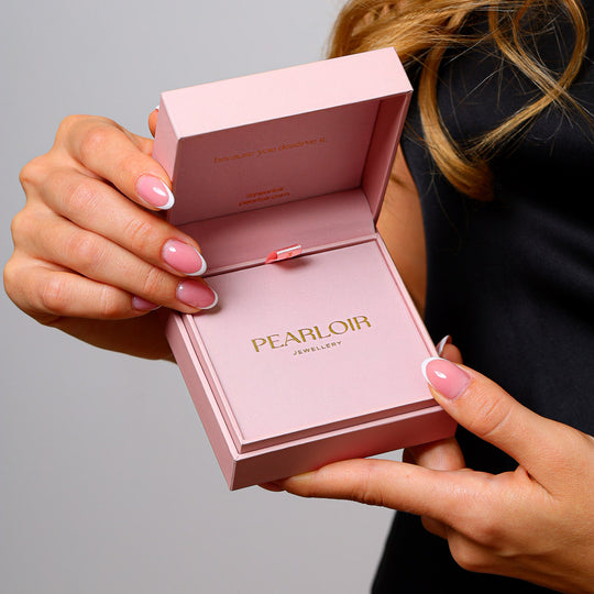 Open Pearloir gift shop package box in pink colour is in a woman’s hand