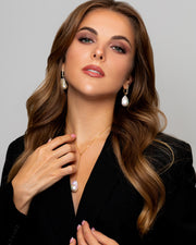 A Caucasian woman wears the large baroque pearl and topaz statement earrings