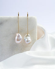 The large Baroque pearls are delicately strung from French hooks on gold chains