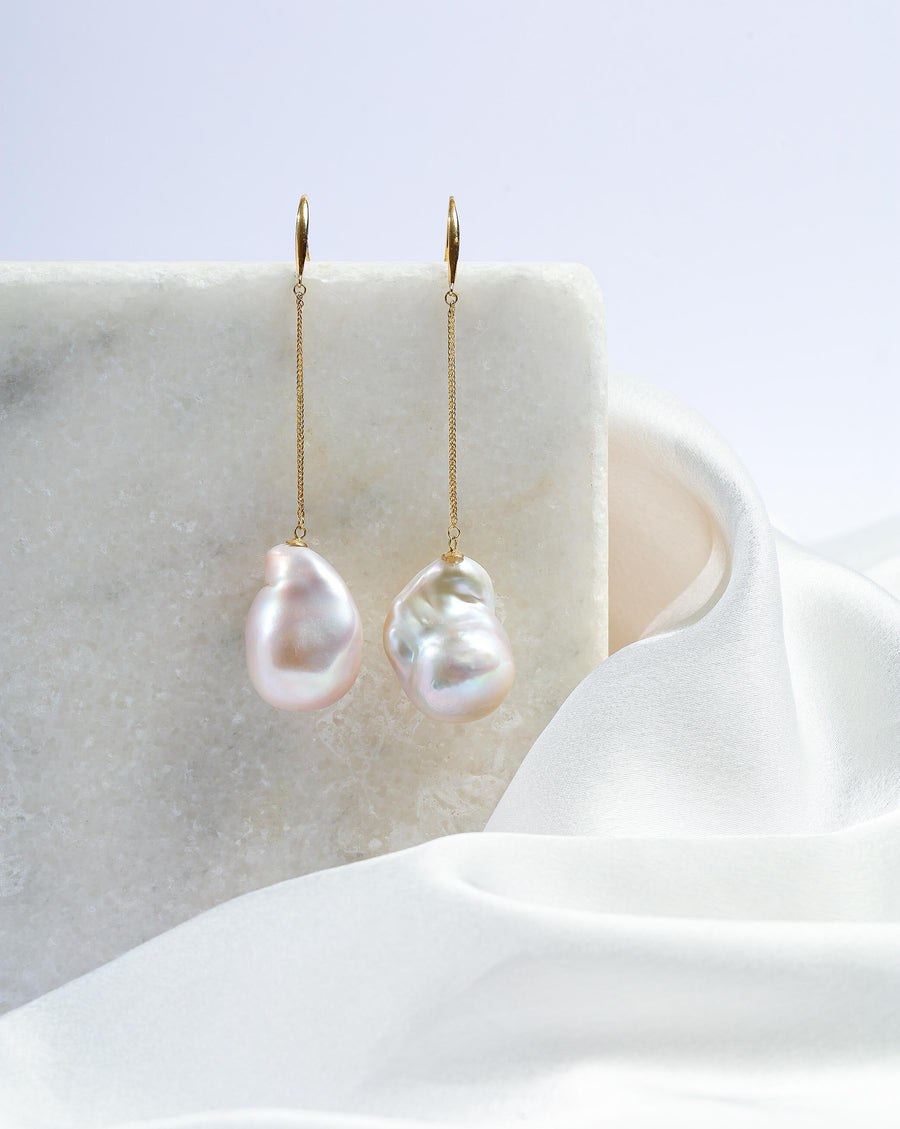 The large Baroque pearls are delicately strung from French hooks on gold chains