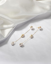 The gold transformer earrings with a delicate Baroque pearl can be worn as studs or shoulder-droppers