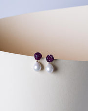 Close up view of transformable dark 1cm ruby gemstone rose studs with 13 mm freshwater Baroque pearls