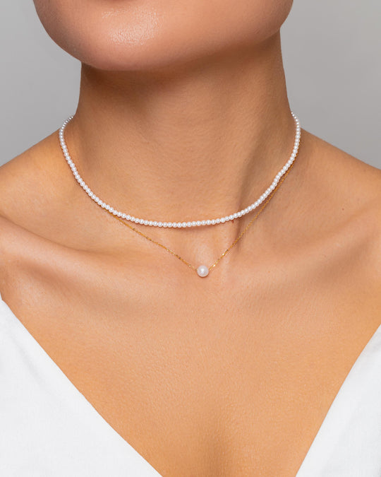 Floating on a beautiful gold chain, the elegant Akoya seawater pearl sits on a woman’s neckline and looks very delicate